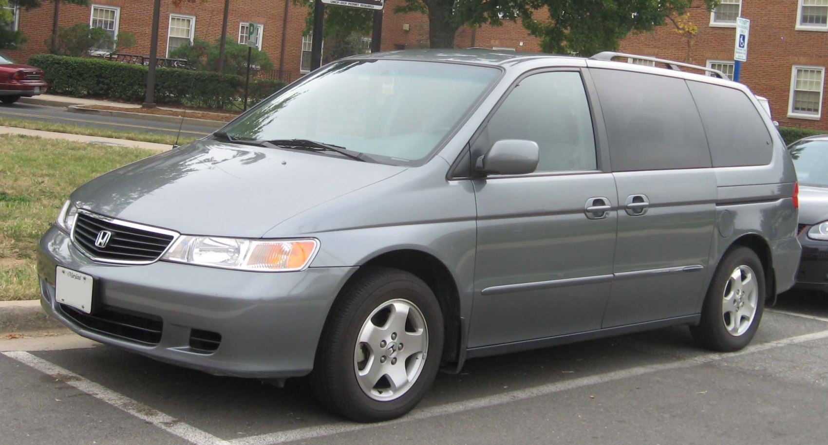 Front side view of a gray mid-size minivan with sliding doors and alloy wheels