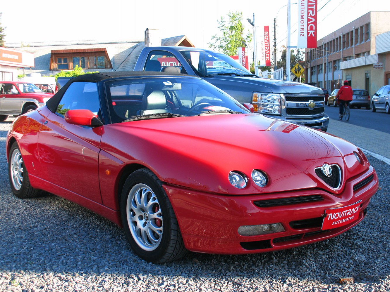 Red convertible sports coupe with dual round headlights and sleek aerodynamic design