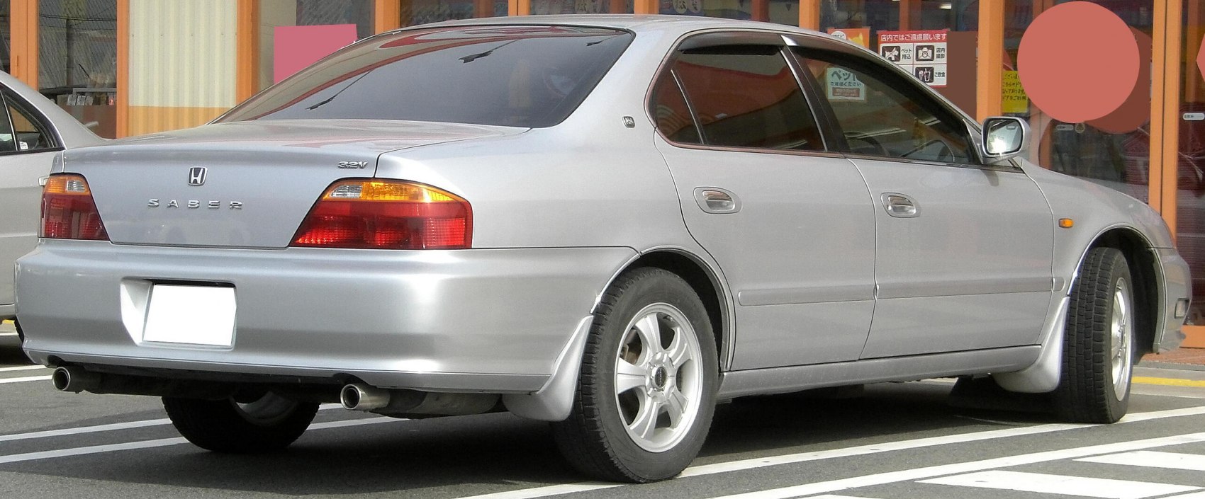 Silver sedan rear and side view with dual exhaust and alloy wheels