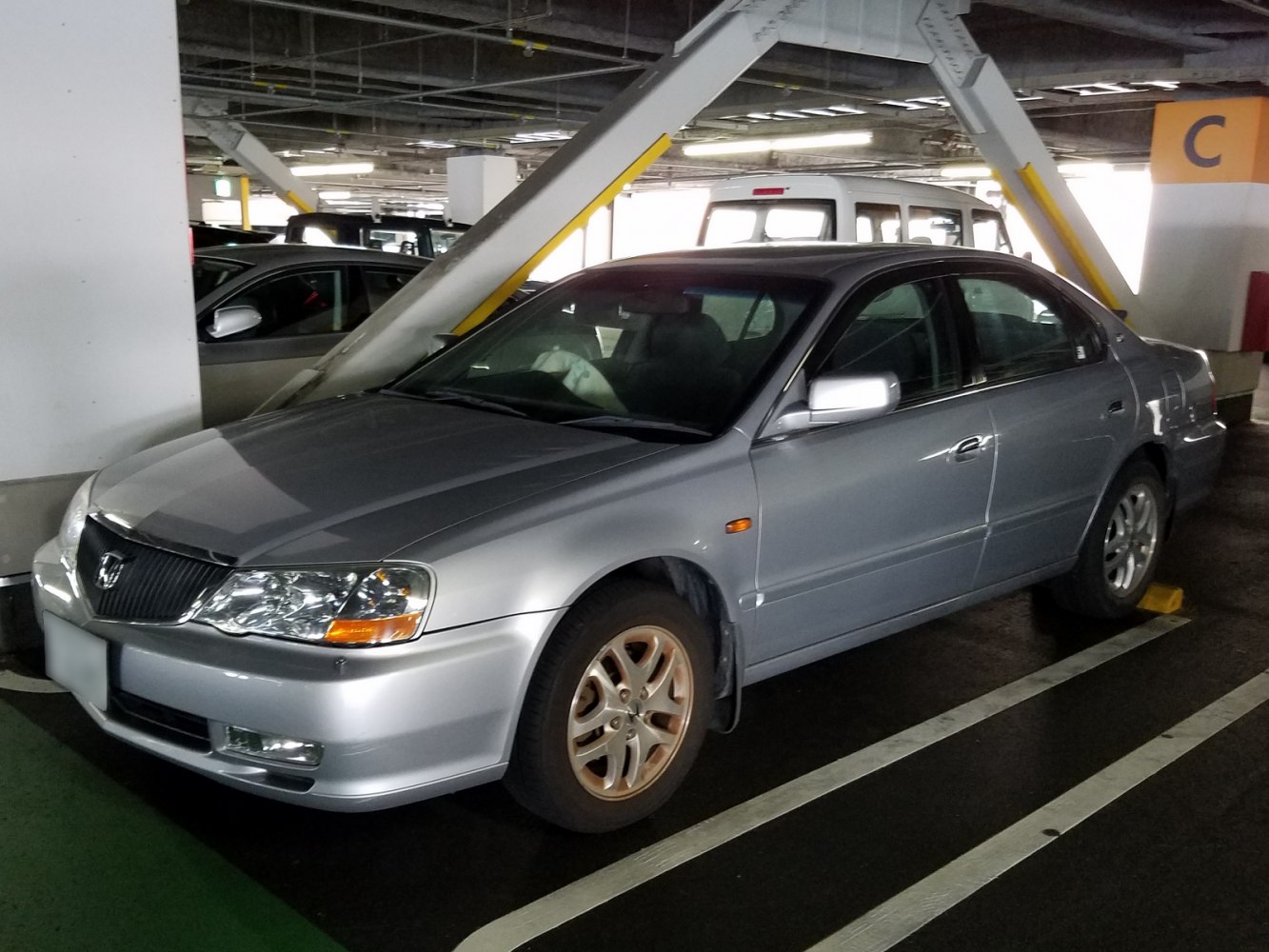Silver sedan front side view with alloy wheels in parking garage