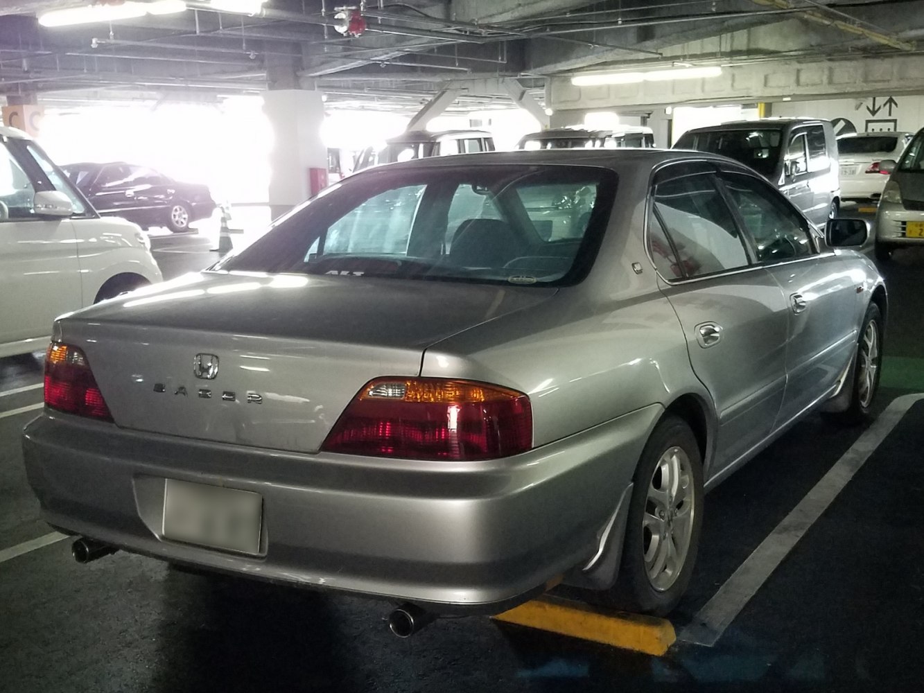 Rear-side view of sedan with dual exhaust and taillight cluster.