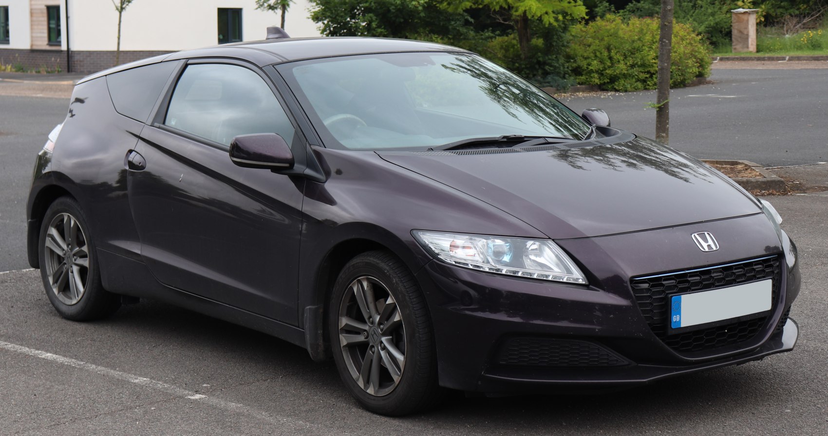 Front left view of compact sports hatchback with sleek headlights and alloy wheels
