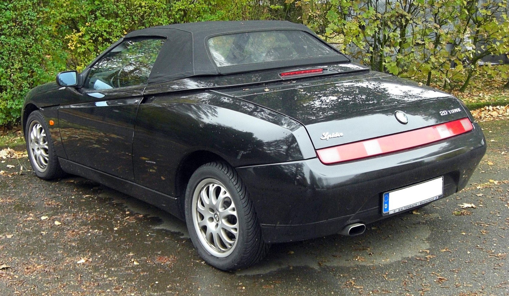 Rear view of sleek black convertible with soft top and rear light bar
