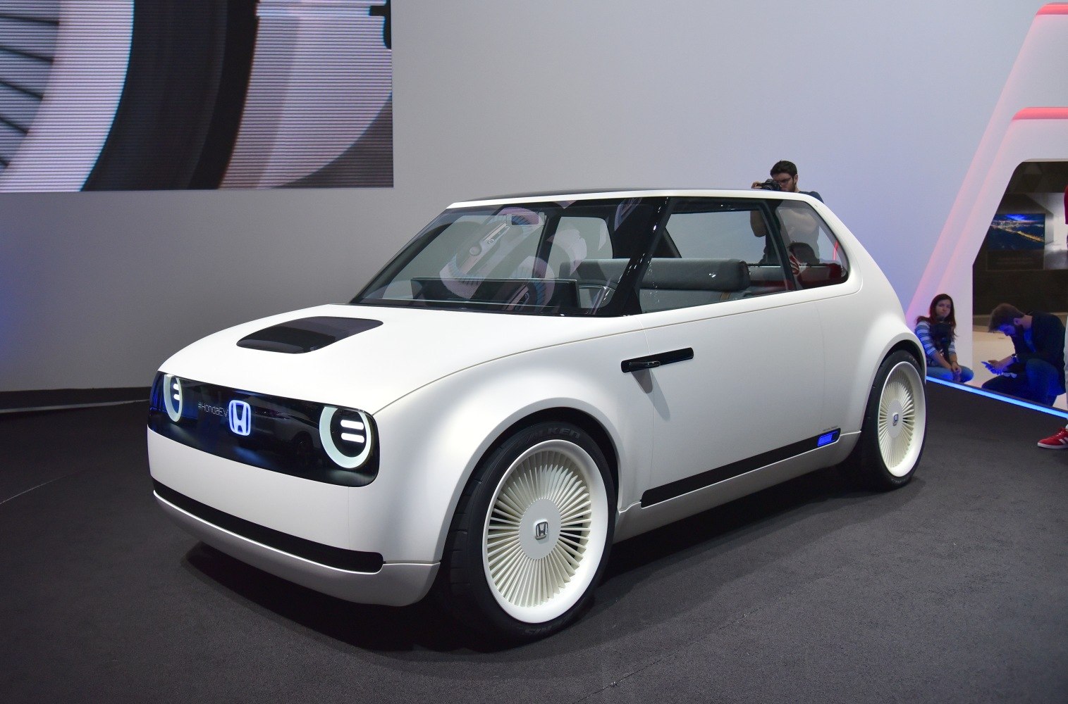 Compact electric vehicle with rounded edges, unique front grille, and turbine-style wheels.