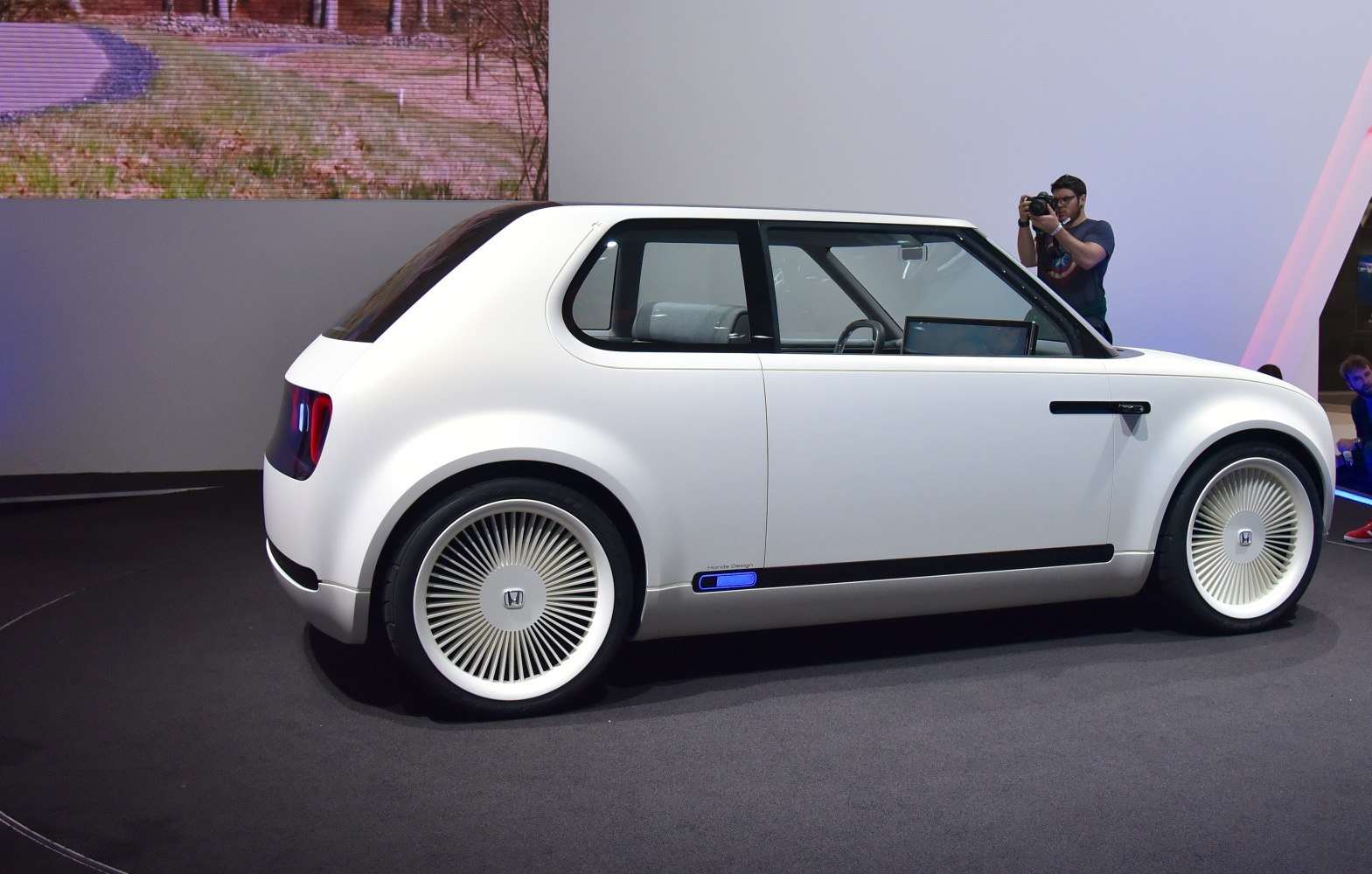 Side profile of a compact retro-futuristic electric vehicle with unique spoked wheels