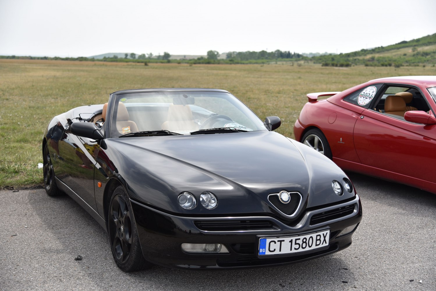 Front view of a convertible with distinctive headlights and open roof
