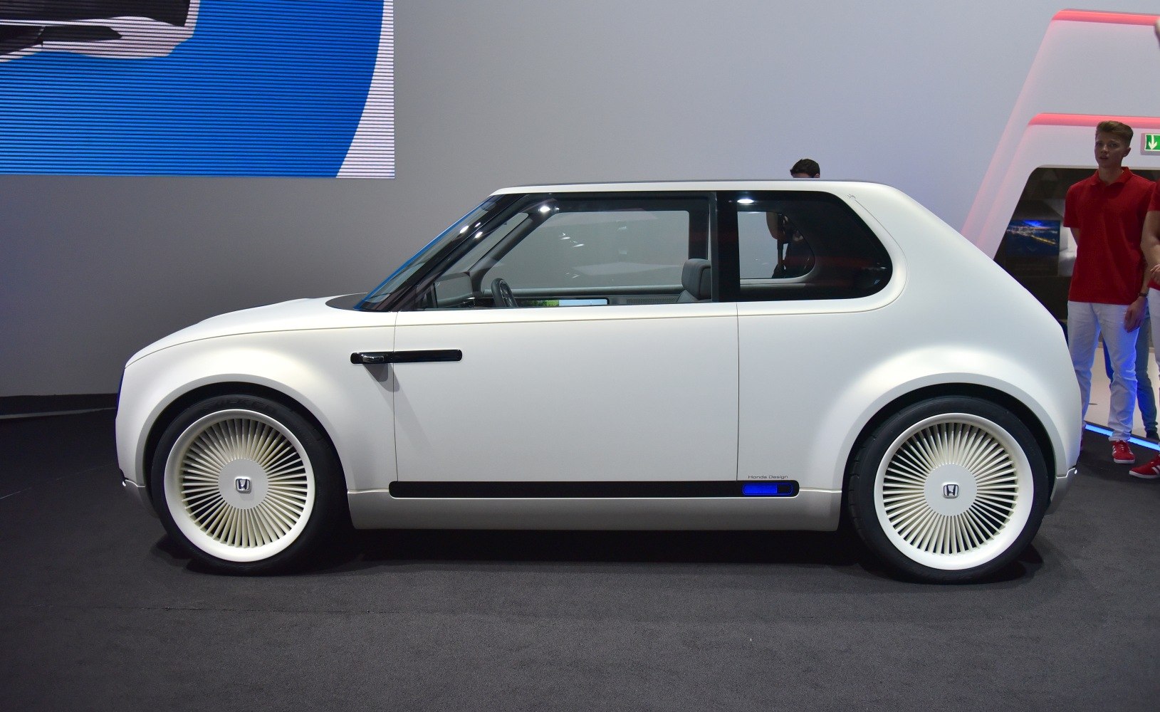 Side profile of a minimalist EV with unique spoke-pattern wheels
