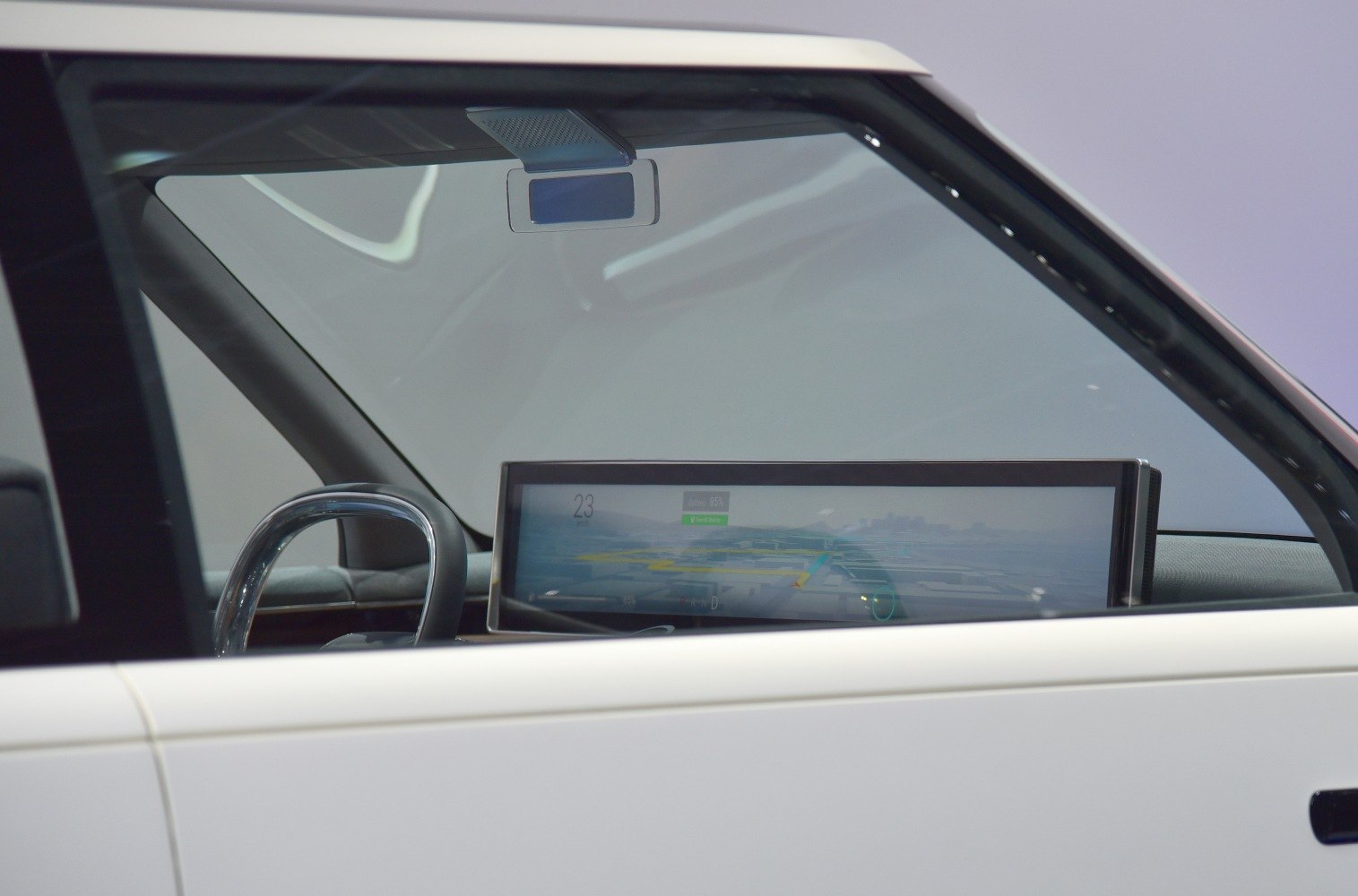 Digital dashboard and minimalist steering wheel inside a concept electric vehicle.