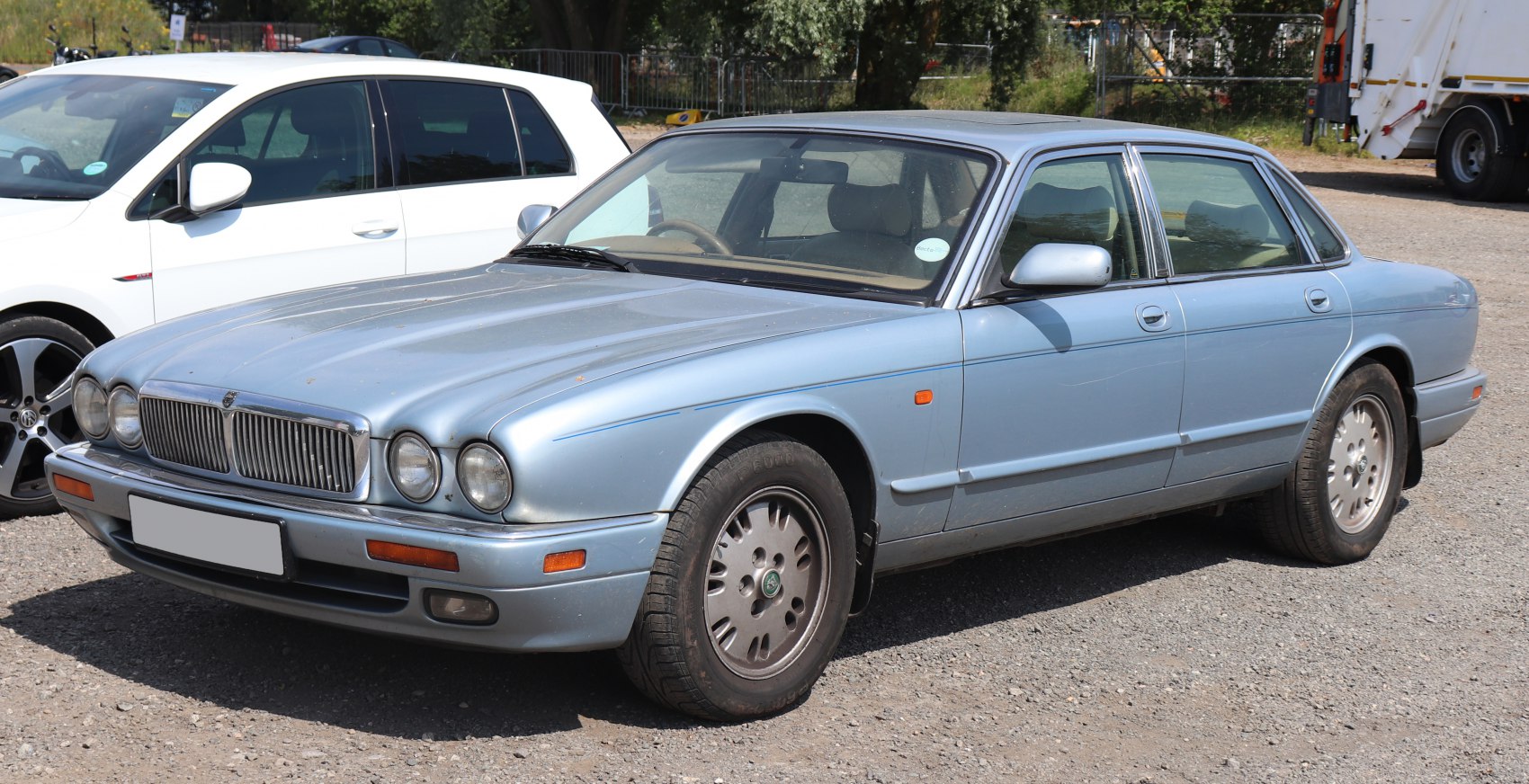 Quad round headlights and prominent chrome grille on a classic mid-90s sedan.
