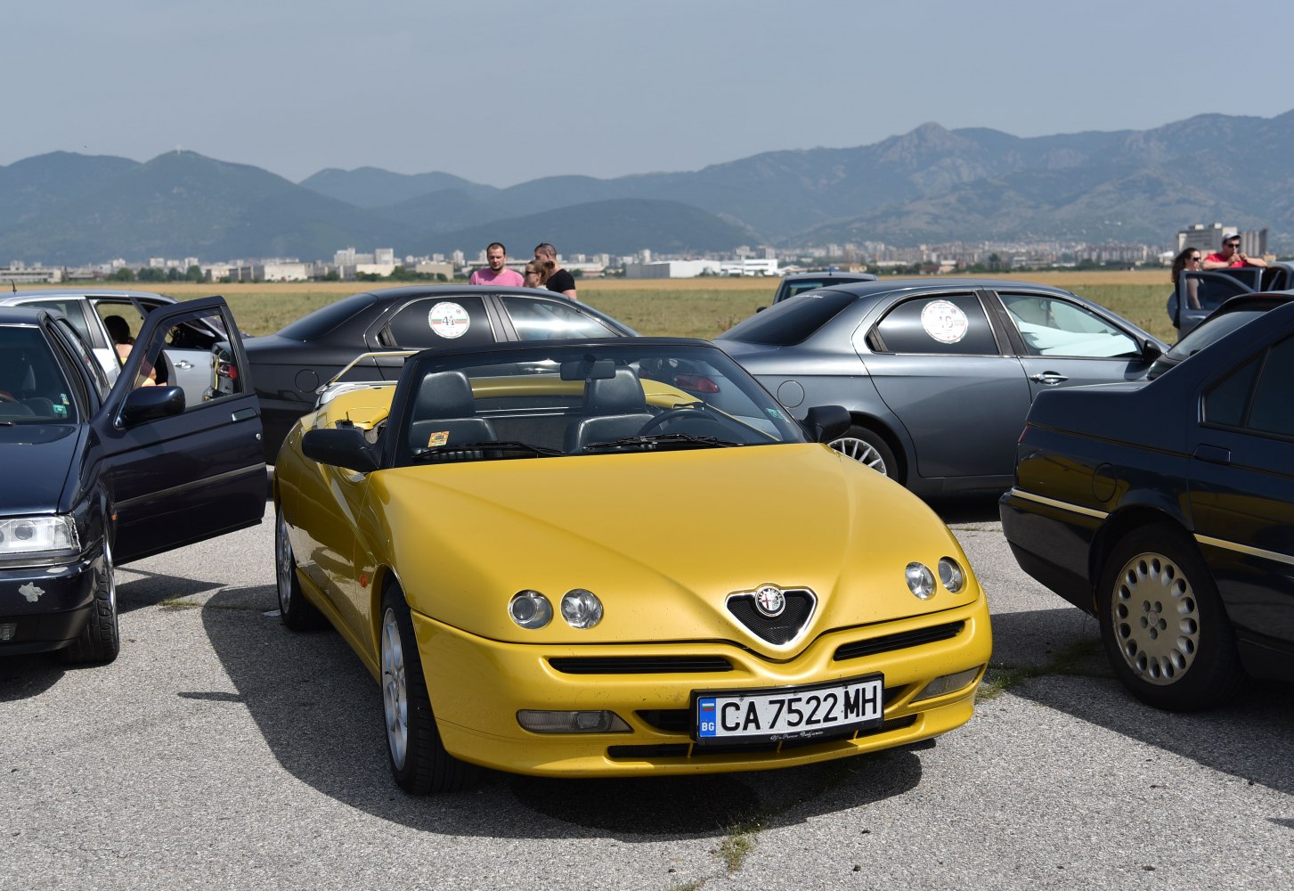 Yellow convertible front view with quad headlights and black interior
