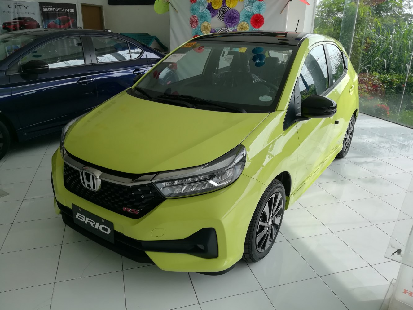Bright yellow compact hatchback with sleek headlights and sporty alloy wheels
