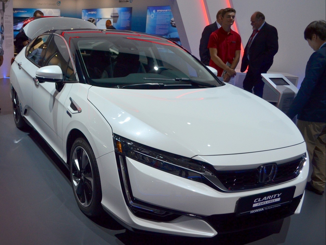 Front view of a white modern vehicle with distinctive LED headlights and a bold grille