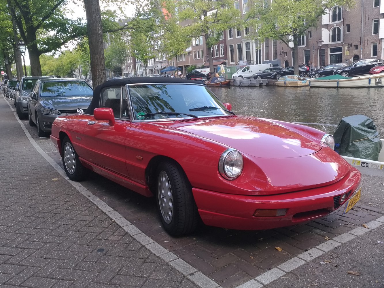 Red convertible with rounded headlights and black soft top