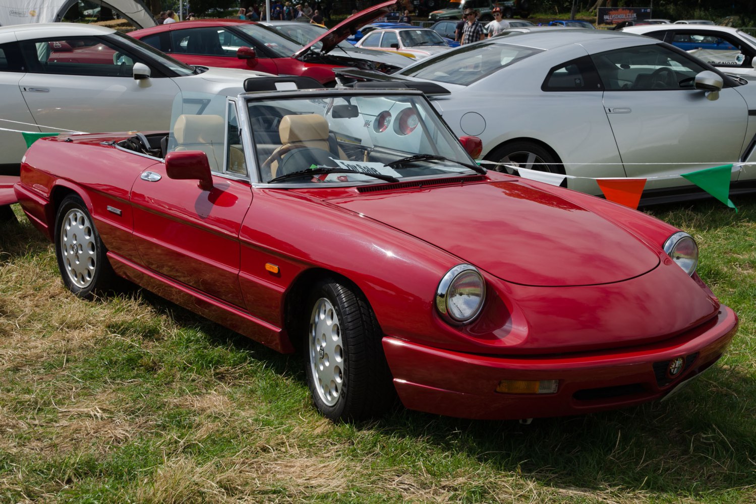 Red convertible with round headlights and sporty, sleek body design