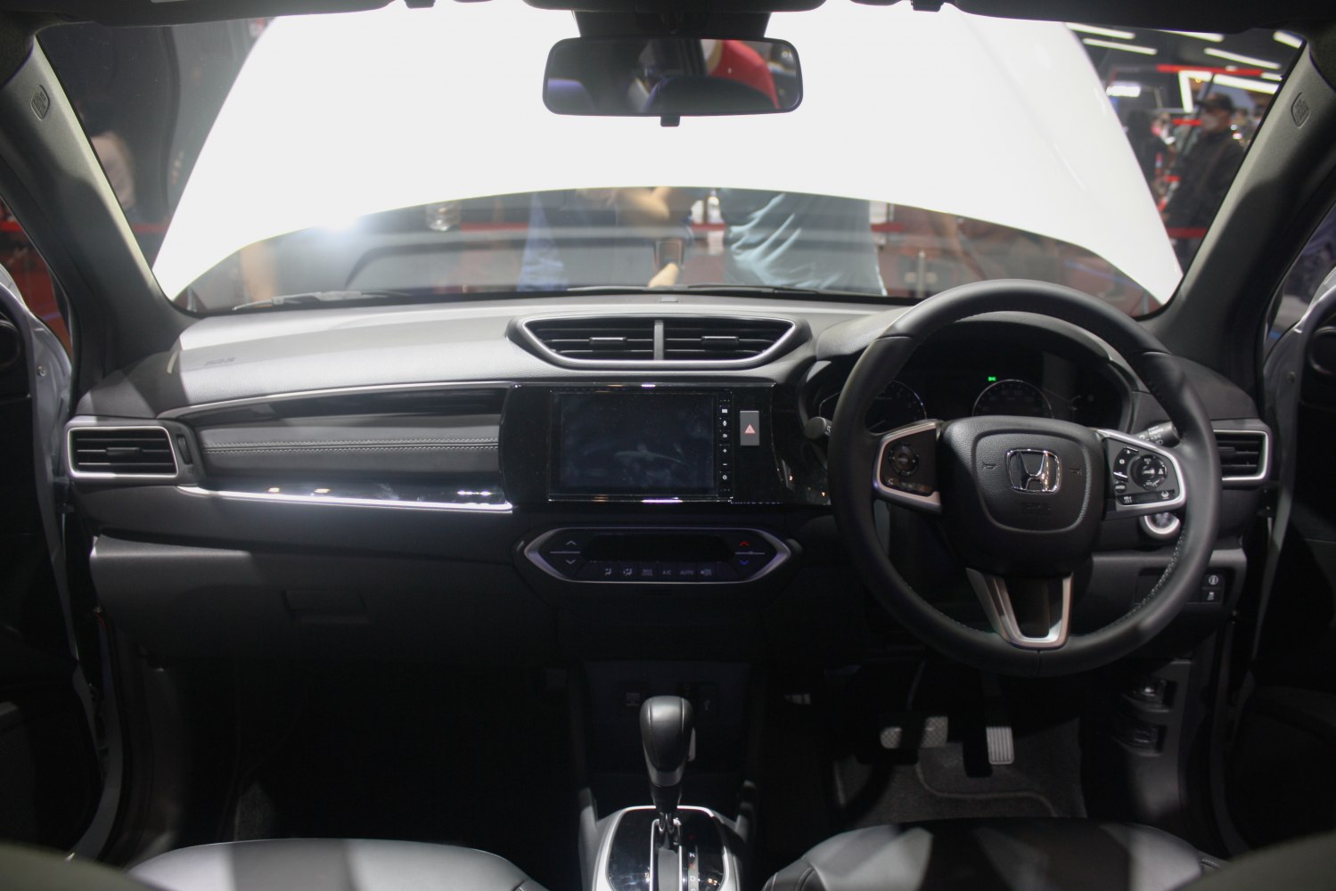 Modern car dashboard with infotainment screen and multifunction steering wheel.