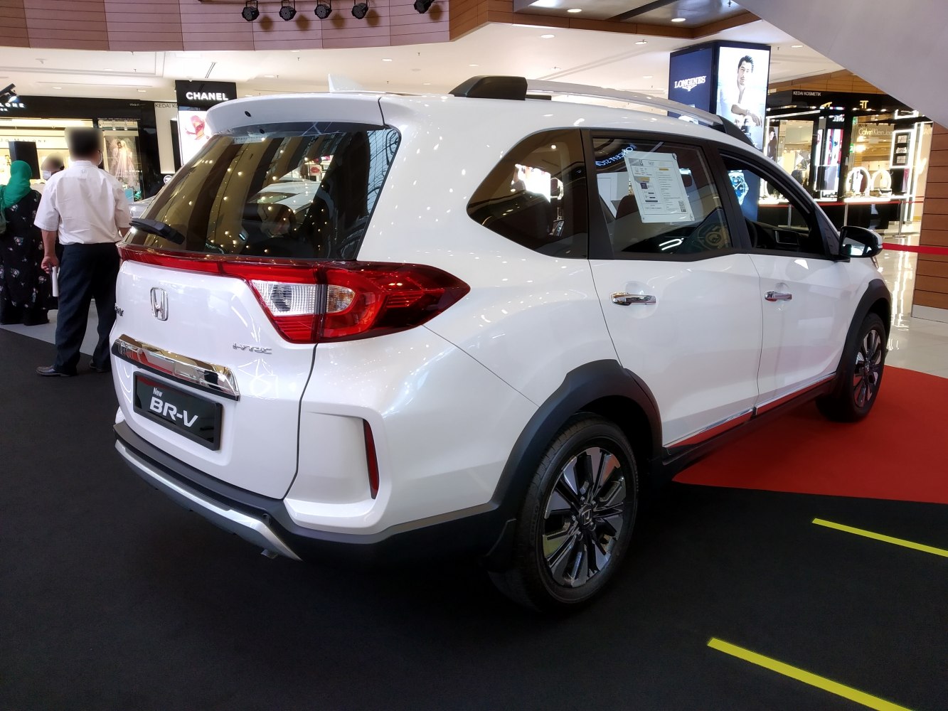 Rear and side view of a white compact SUV with modern design features.