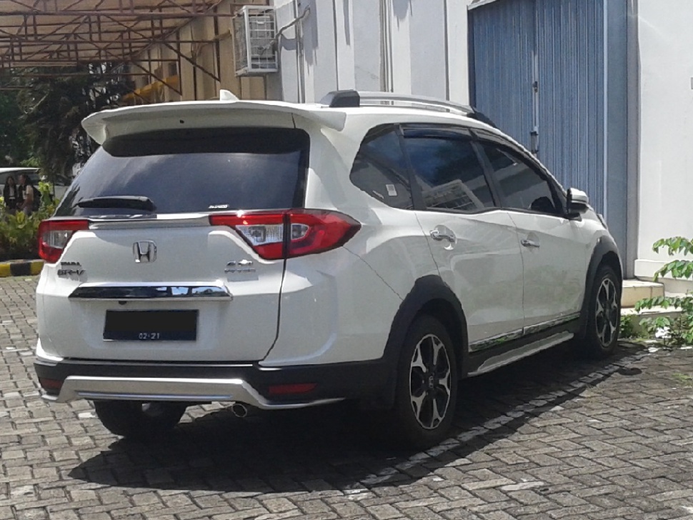 White compact SUV rear view with spoiler, tinted windows, and alloy wheels.