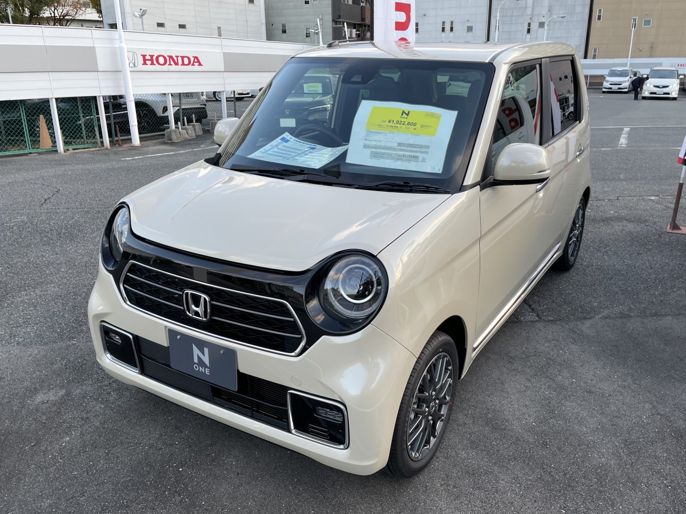 Beige compact car with round headlights and black accented grill.
