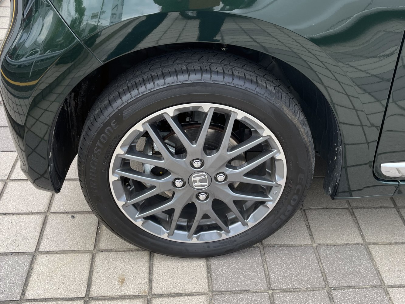 Close-up of multi-spoke alloy wheel with tire tread.