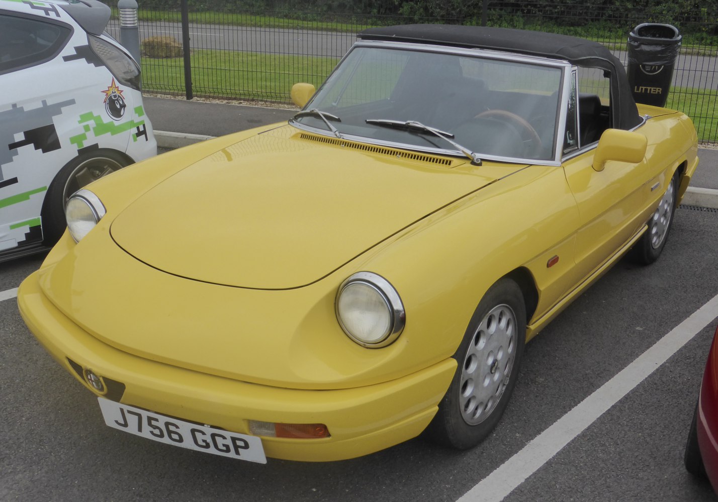 Yellow convertible with round headlights and black soft top