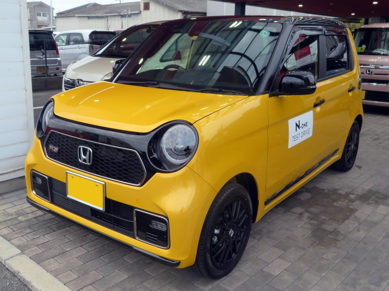 Compact hatchback with round headlights and black honeycomb grille