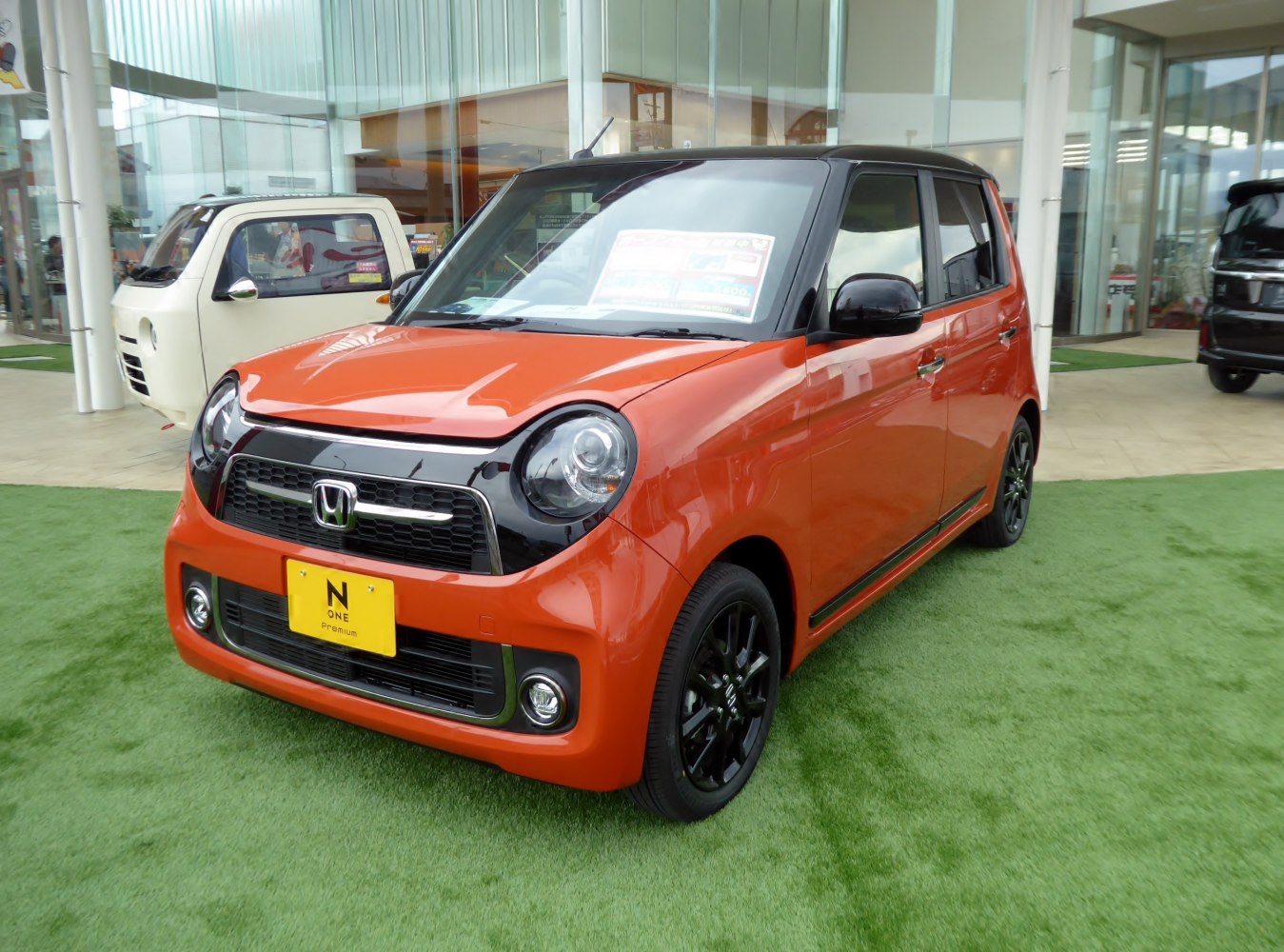 Compact hatchback with round headlights and black front grille.