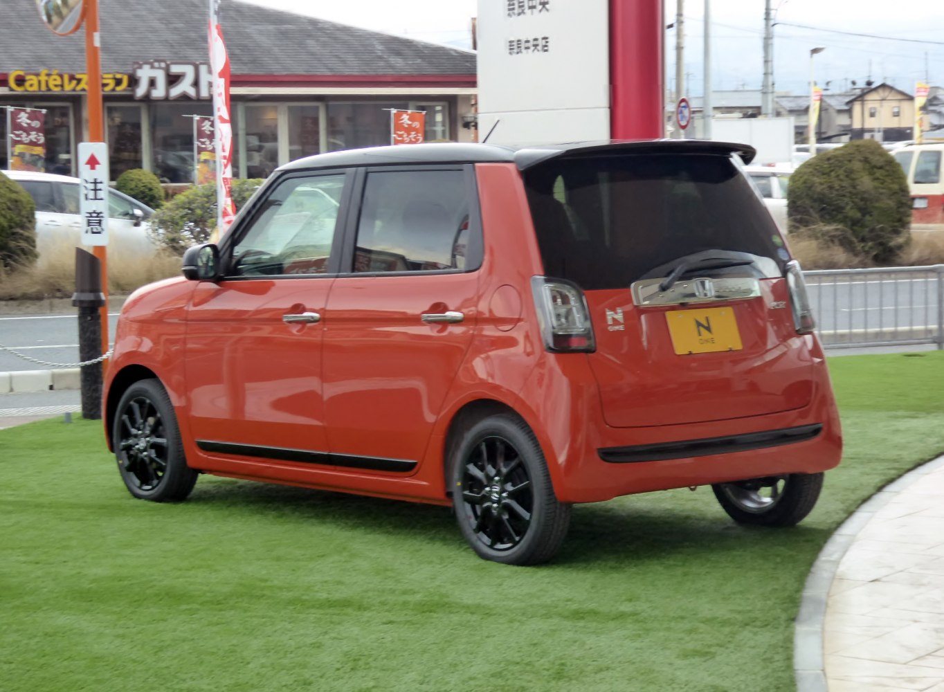 Rear and side view of compact hatchback with black alloy wheels and black roof.