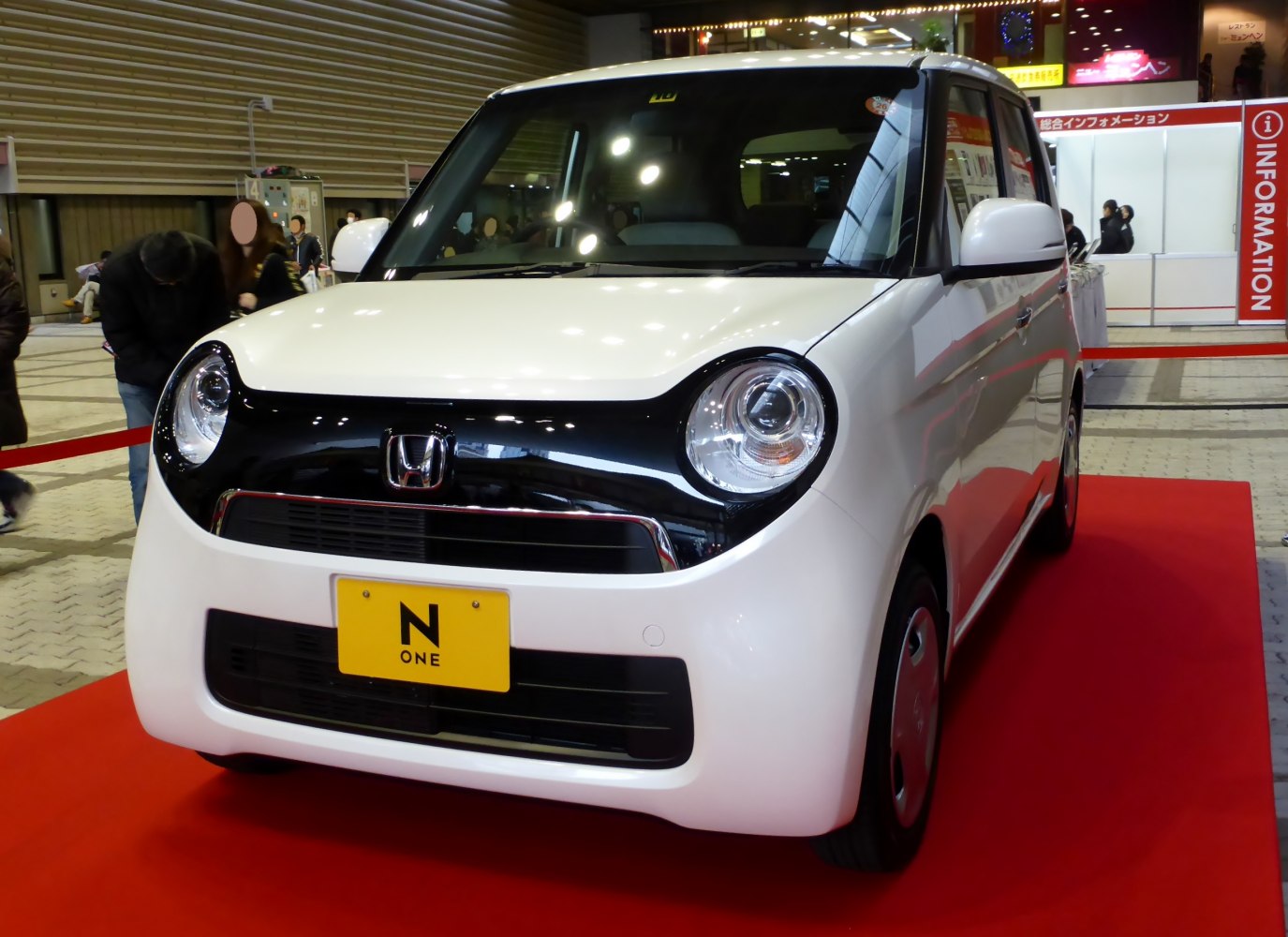 Compact vehicle front with black grille and round headlights