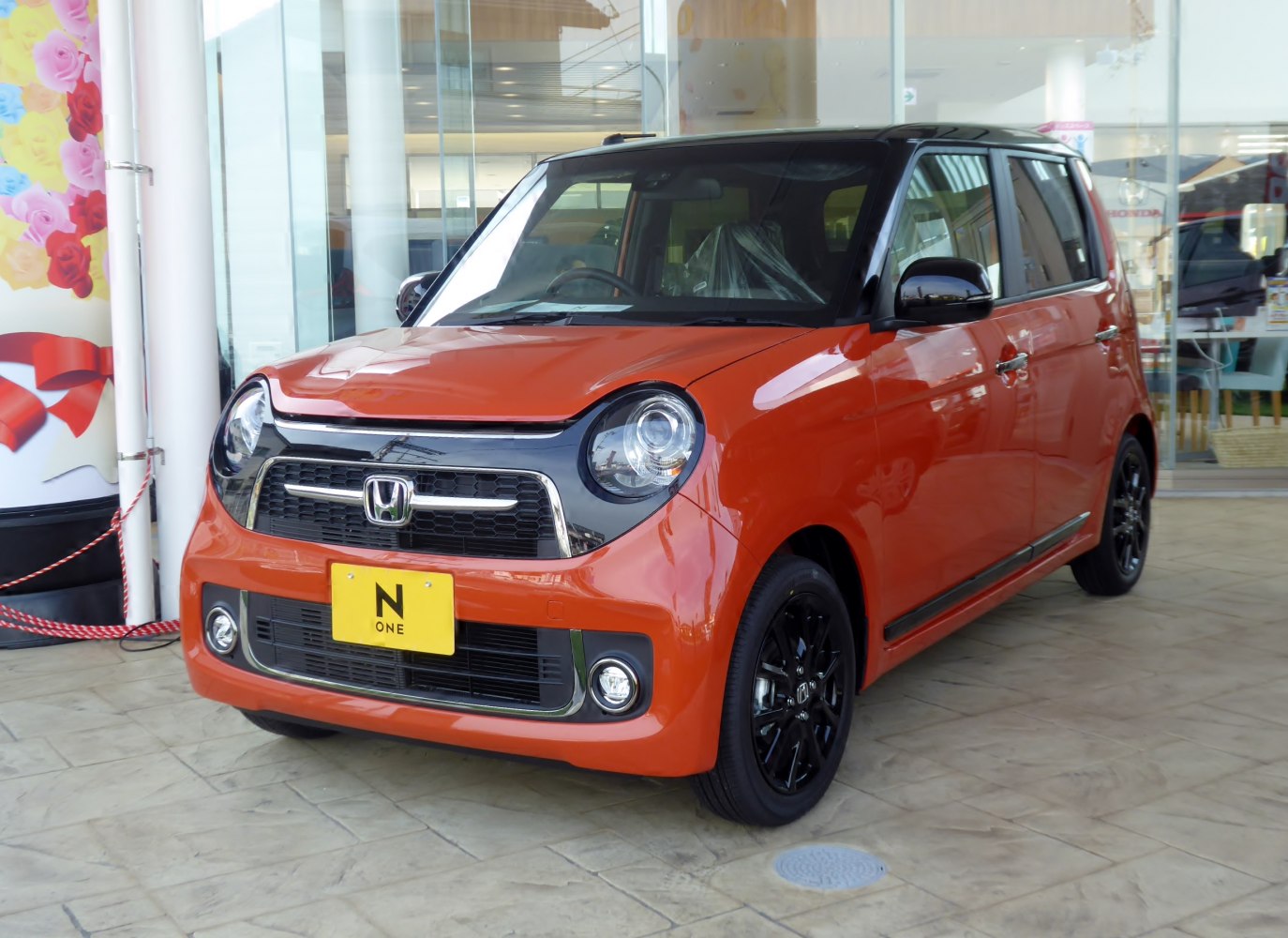 Compact orange and black car with round headlights and black alloy wheels