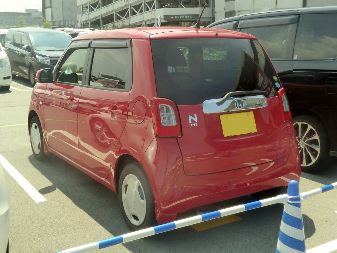Compact kei car rear view with distinctive tail lights and rear wiper.