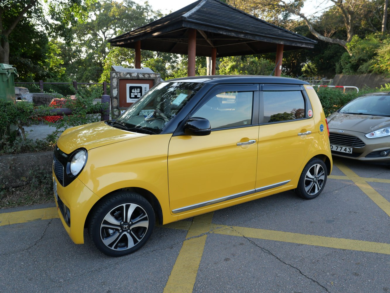 Compact hatchback with rounded headlights and two-tone yellow-black design