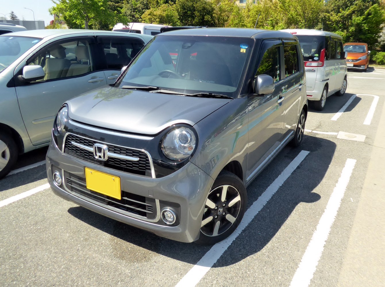 Compact kei car with round headlights and unique front grille.