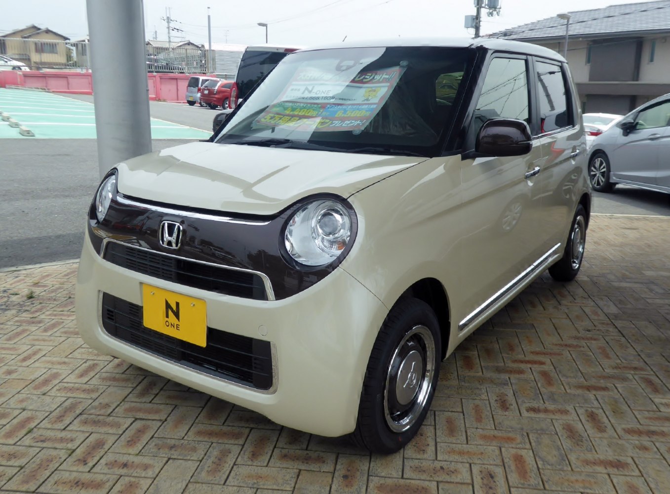 Compact kei car with rounded headlights and two-tone paint design.