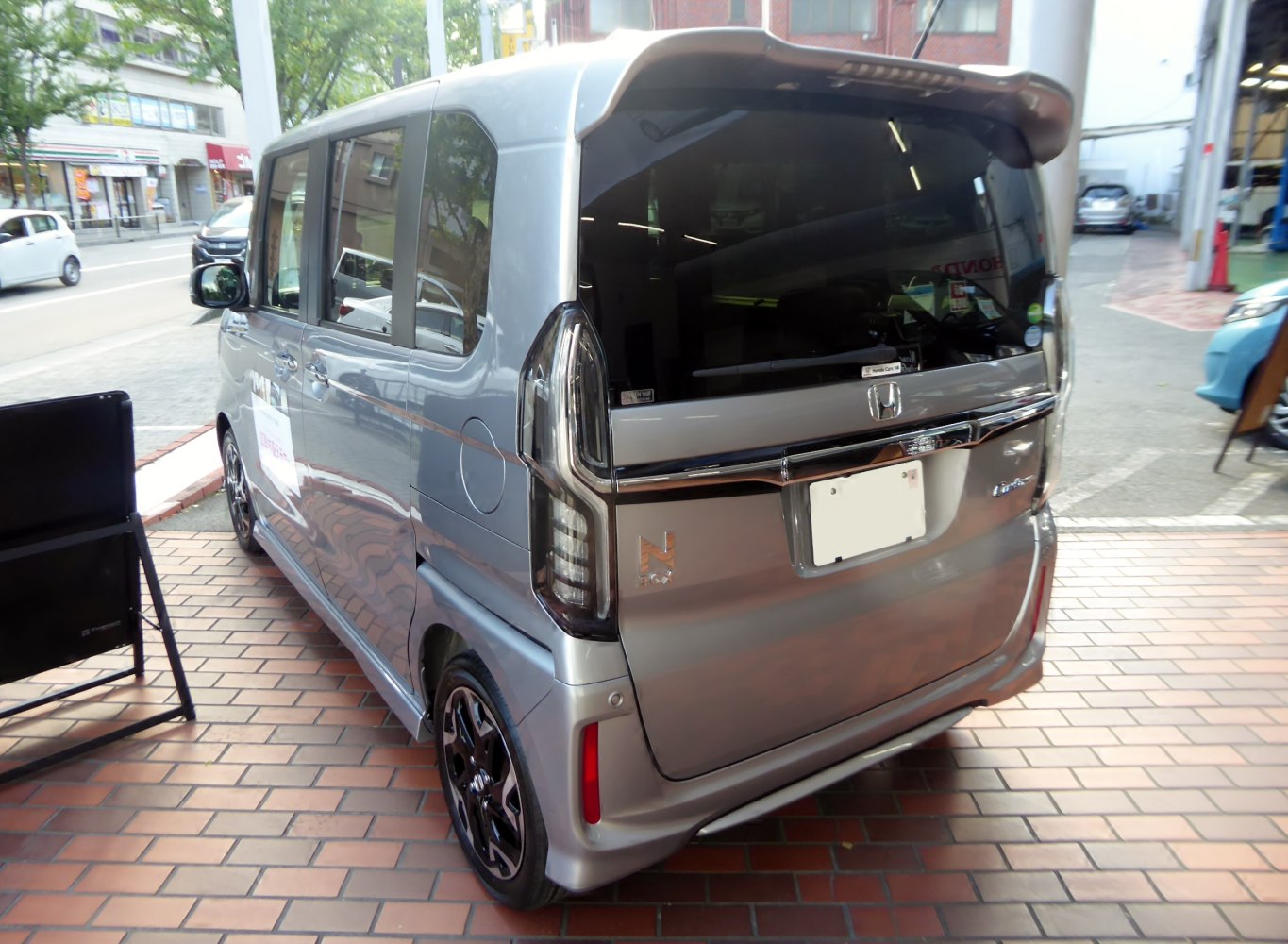 Compact vehicle rear with vertical taillights and roof spoiler