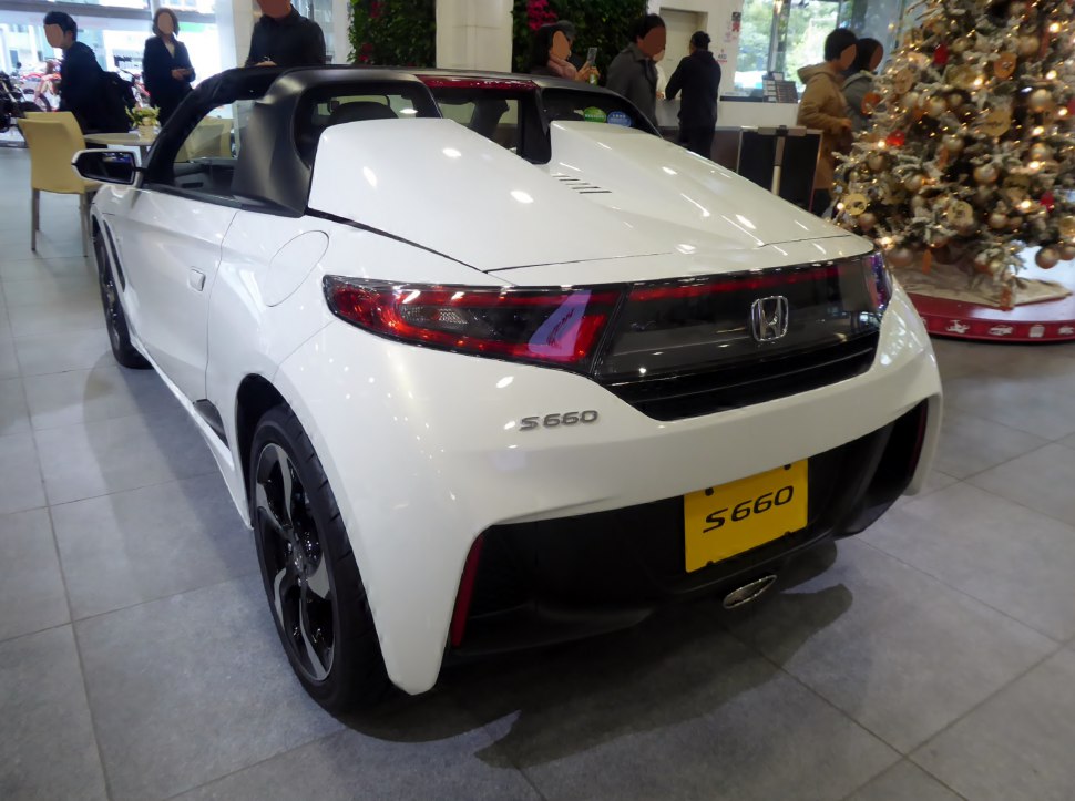White convertible sports car rear with distinct taillights and aerodynamic rear design