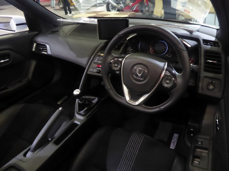 Steering wheel, manual gear shift, dashboard, and center console interior features.
