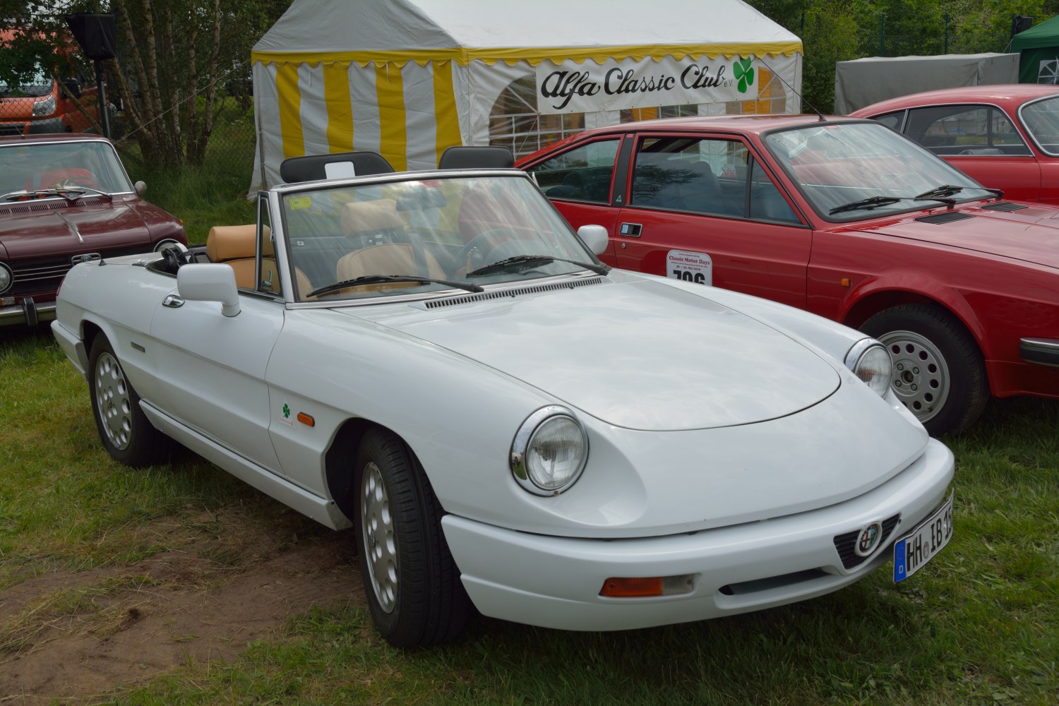 White convertible roadster with round headlights and leather interior