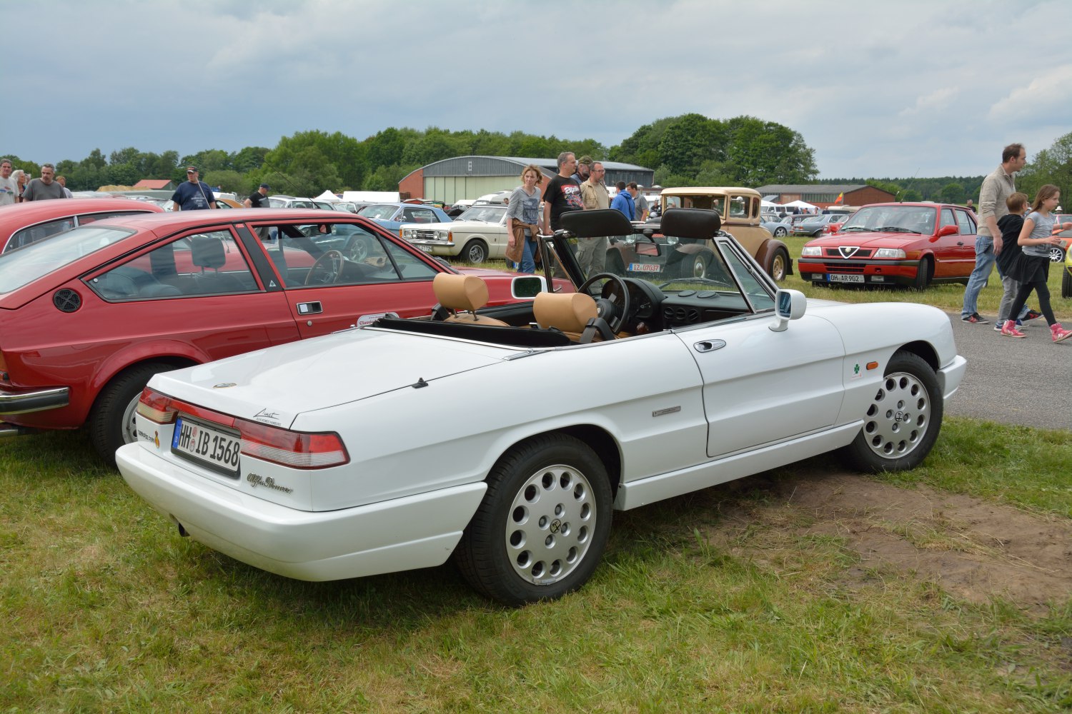 White convertible with tan seats, rear and side profile