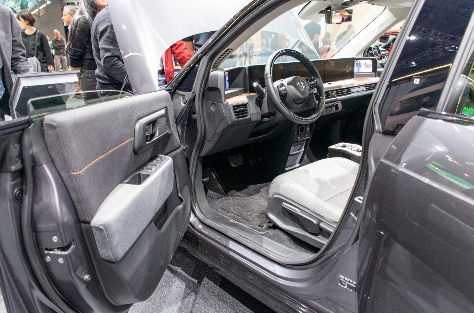 Modern compact electric vehicle interior with digital dashboard and fabric door panel