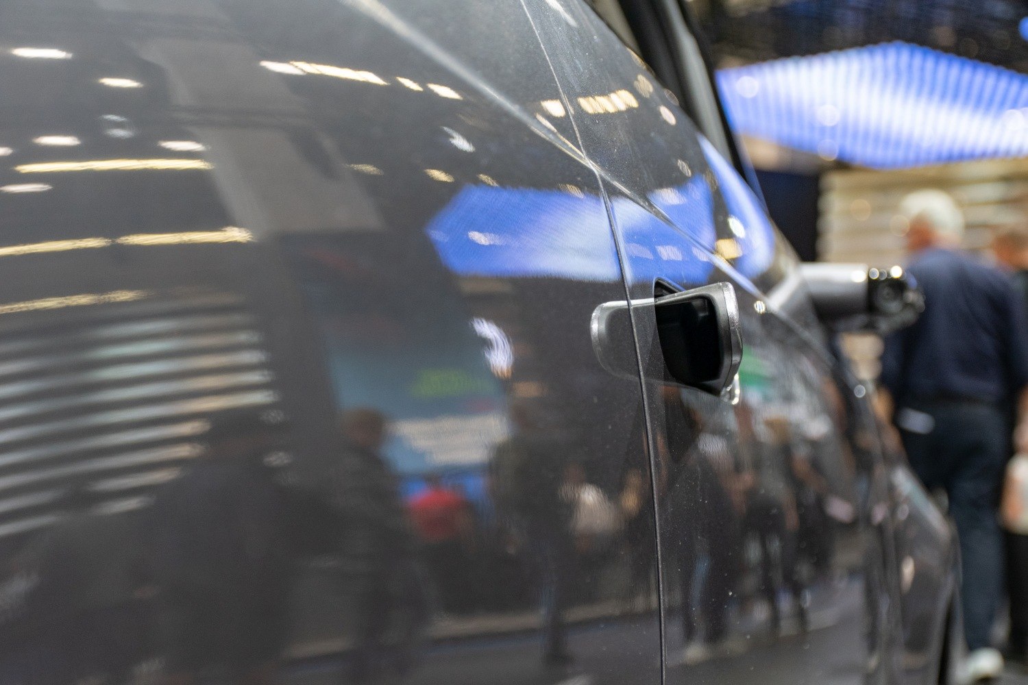 Close view of a side door handle on a dark vehicle surface