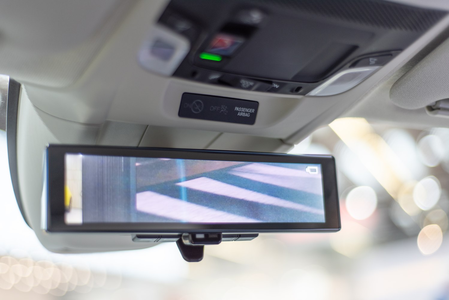 Digital rearview mirror with camera display and passenger airbag indicator
