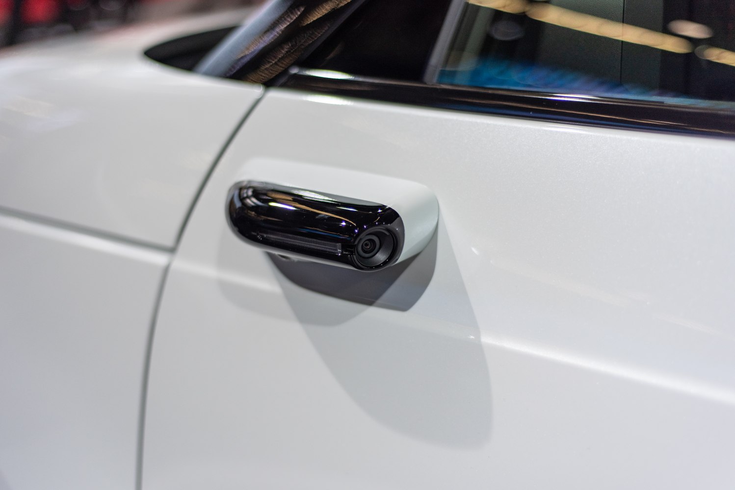 Close-up of a digital side mirror with integrated camera on a vehicle door