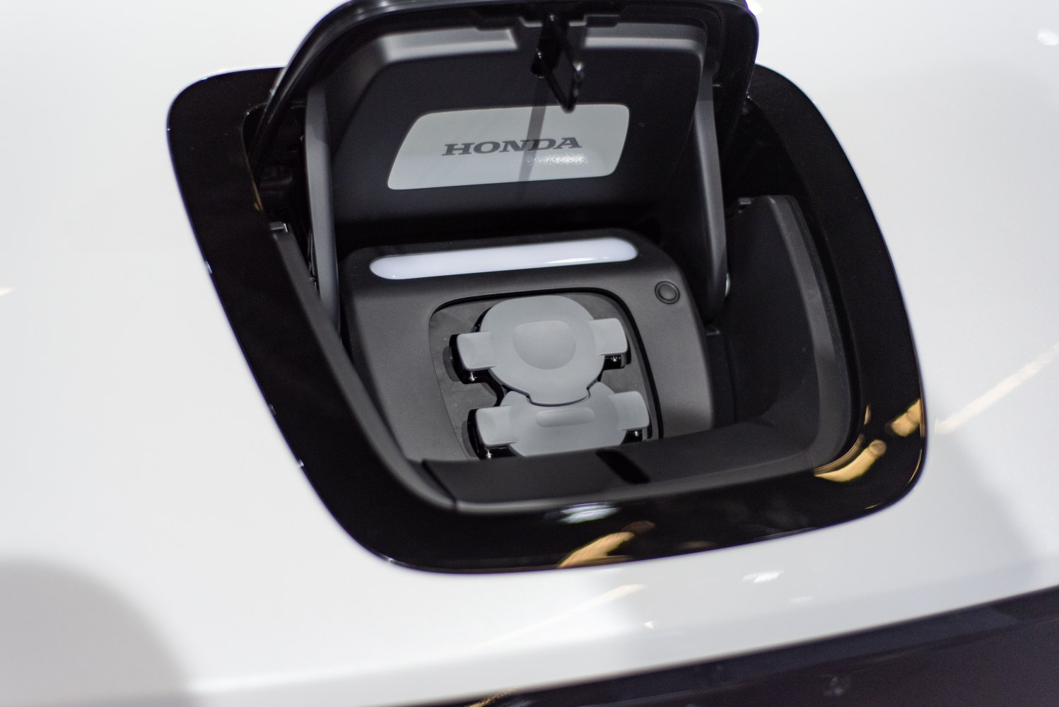 Close-up of electric vehicle charging port with Honda branding