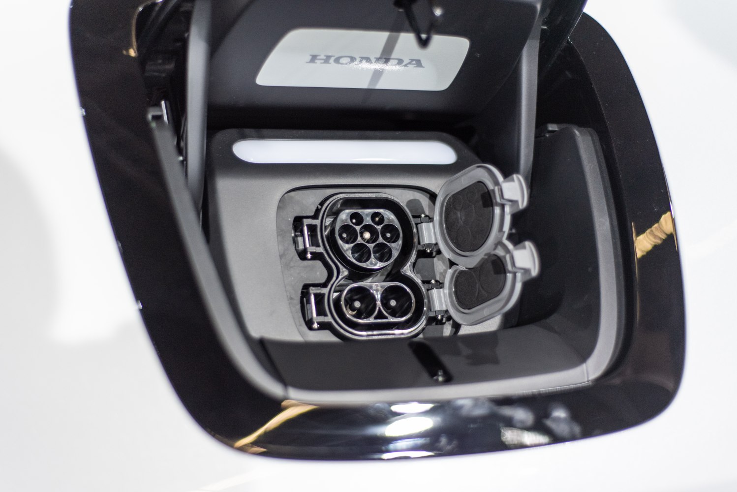 Close-up of electric vehicle charging port with connector and protective caps