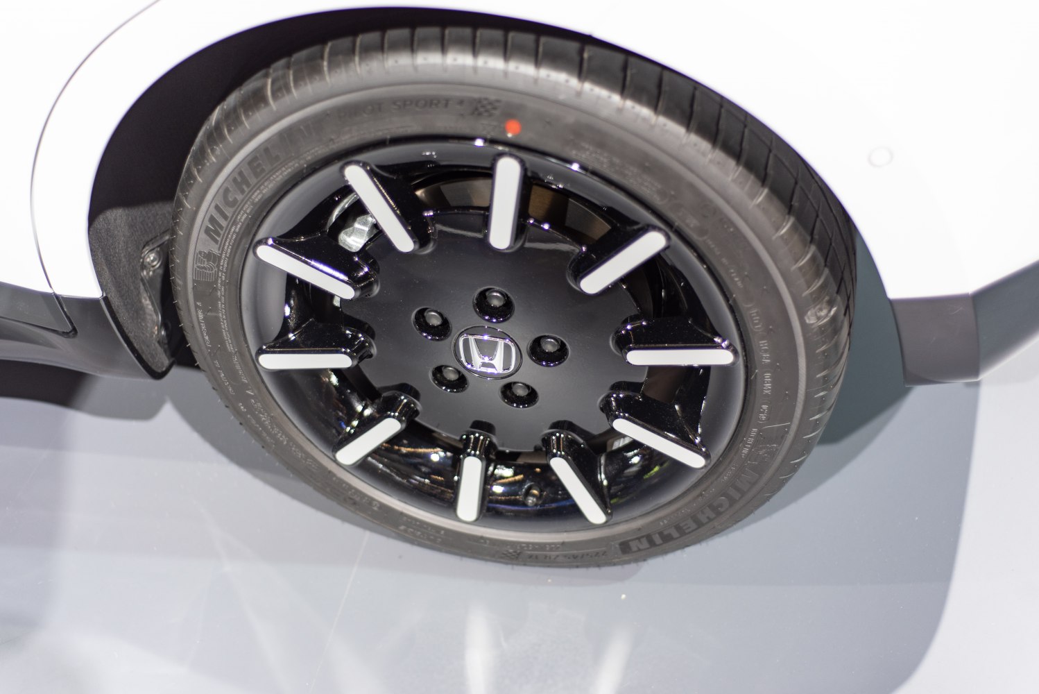 Black alloy wheel with white accents on Michelin Pilot Sport tire