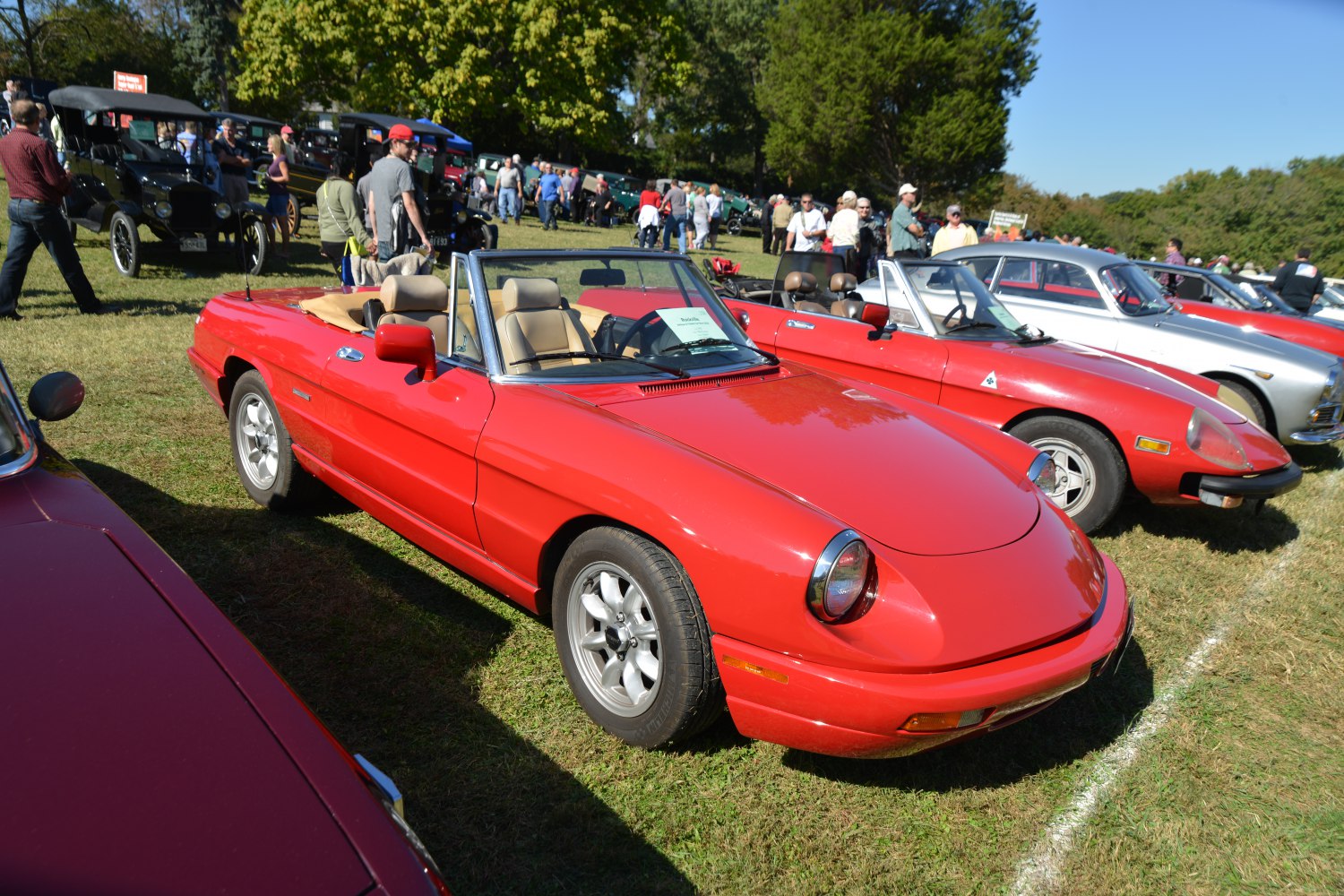 Red convertible sports car with round headlights and chrome wheels