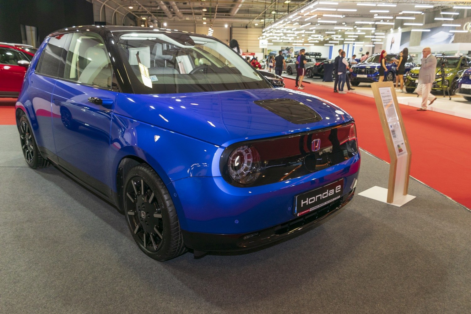 Compact electric vehicle front view with round LED headlights and glossy finish