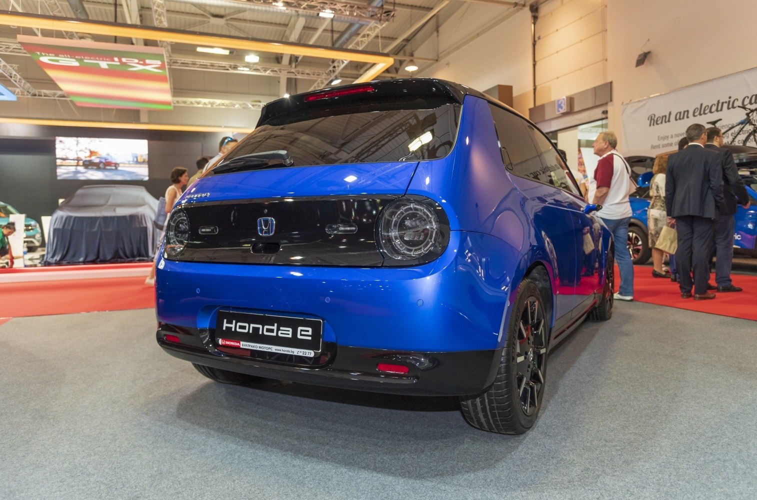 Rear view with rounded taillights, black panel, and compact hatchback design.