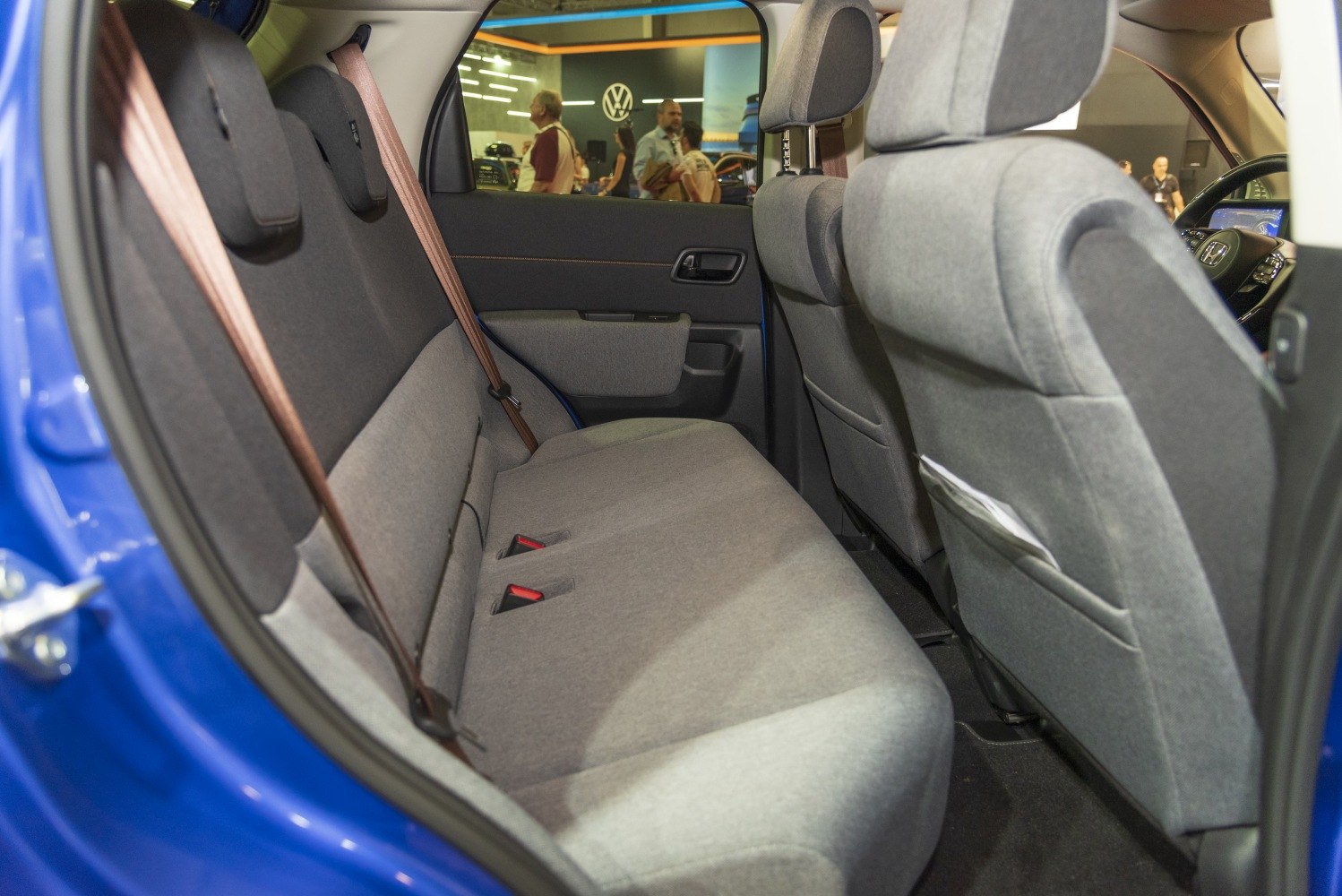 Rear seat interior with gray fabric upholstery and brown seatbelts