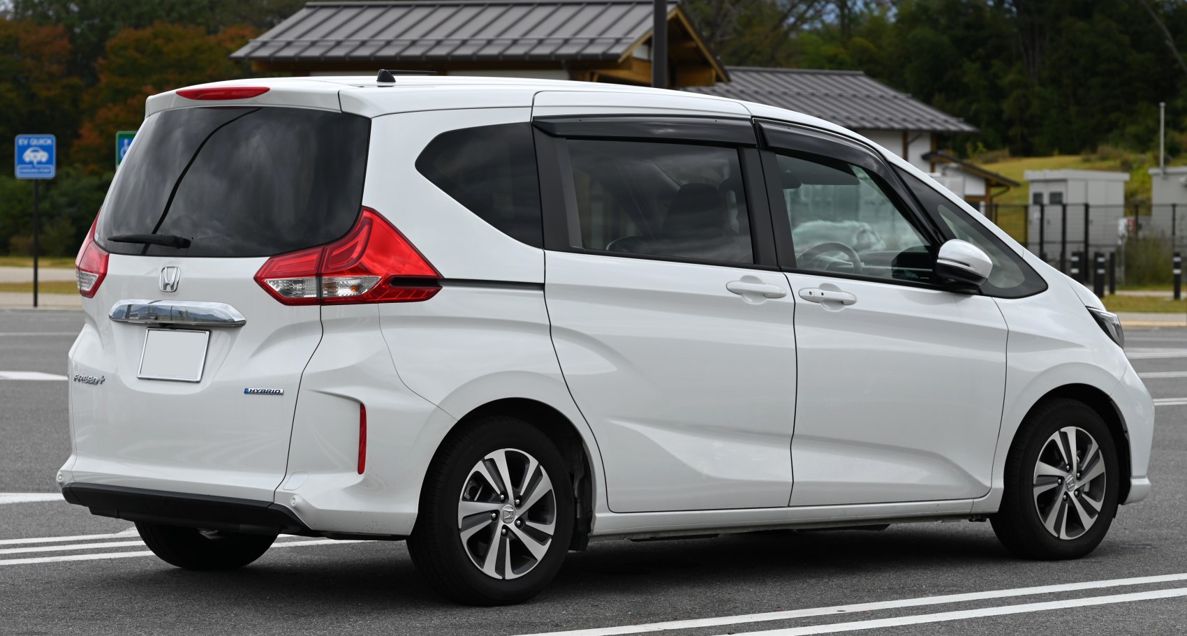 Rear side profile of a hybrid minivan with sliding door and distinctive tail lights
